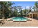 Community pool surrounded by lounge chairs, landscaping, and a covered cabana area at 950 Broadway # 103, Dunedin, FL 34698