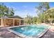 Community pool with cabana, lounge chairs, and tropical landscaping under a bright blue sky at 950 Broadway # 103, Dunedin, FL 34698