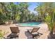 Relaxing pool area with lounge chairs, a dining table, and beautiful tropical landscaping at 950 Broadway # 103, Dunedin, FL 34698