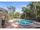 Community swimming pool surrounded by lush landscaping, lounge chairs, and a cabana area at 950 Broadway # 103, Dunedin, FL 34698