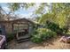 Charming house with a covered porch surrounded by lush landscaping, creating a cozy entrance at 9810 Parsons St, Tampa, FL 33615