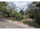 Property exterior showcasing yard, mature trees, and a fence along the street at 9810 Parsons St, Tampa, FL 33615