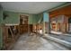Open-concept living space featuring damaged walls and flooring awaiting full renovation at 9810 Parsons St, Tampa, FL 33615