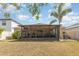Exterior view of the home's backyard and screened in patio featuring comfortable outdoor seating and lush landscaping at 10036 Crested Fringe Dr, Riverview, FL 33578