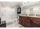 Bathroom featuring dual sinks, granite countertops, and a glass-enclosed shower at 10036 Crested Fringe Dr, Riverview, FL 33578