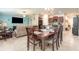 Inviting dining area with wood table, tile floors, and open floor plan to the kitchen and living area at 10036 Crested Fringe Dr, Riverview, FL 33578