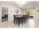 Bright dining area with elegant chandelier, tile floors, and sliding glass doors to the outdoor patio at 10036 Crested Fringe Dr, Riverview, FL 33578