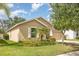 Tan home with a well-maintained lawn, complemented by a lush palm tree, and a tidy exterior at 10036 Crested Fringe Dr, Riverview, FL 33578