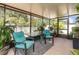 A screened patio features comfortable seating, a table, an area rug, and plants and a view to the back yard at 10036 Crested Fringe Dr, Riverview, FL 33578