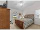 A cozy bedroom with a natural wood bed frame and an arched window at 1017 Hamilton Ave, Tarpon Springs, FL 34689