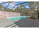 Relax in this stunning screened-in pool with spacious decking and serene privacy curtains at 1017 Hamilton Ave, Tarpon Springs, FL 34689