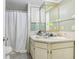 A practical bathroom featuring double sinks, tiled shower with shower curtain, and ample lighting at 10565 Bessemer St, New Port Richey, FL 34654