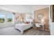 Bright bedroom features a comfortable bed with an accent wall, and a scenic view through a large window at 10589 Farm Hill Ave, Land O Lakes, FL 34638