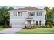 Charming two-story home features gray siding, stone accents, and a well-manicured lawn at 10589 Farm Hill Ave, Land O Lakes, FL 34638
