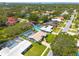 Aerial view of a residential neighborhood showcasing a blue home with a screened pool and lush greenery at 1101 Mclean St, Dunedin, FL 34698