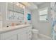 Cozy bathroom featuring a quartz countertop vanity and a decorative blue shower curtain at 1101 Mclean St, Dunedin, FL 34698
