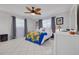 Bright bedroom featuring tile floors, stylish ceiling fan and decorative tropical-themed bedding at 1101 Mclean St, Dunedin, FL 34698
