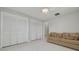 Large bedroom with tile floor, multiple closets, a comfortable couch and open access to the bathroom at 1101 Mclean St, Dunedin, FL 34698
