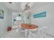 Bright dining room featuring an oval wooden table, white chairs, and a view to the kitchen at 1101 Mclean St, Dunedin, FL 34698
