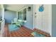 Inviting front porch featuring tile flooring, green chairs, and decorative door decor at 1101 Mclean St, Dunedin, FL 34698