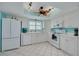 Bright kitchen with white cabinets, appliances, and a window over the sink at 1101 Mclean St, Dunedin, FL 34698