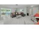 Bright living room featuring tile flooring, a plush gray sectional, and access to the enclosed patio at 1101 Mclean St, Dunedin, FL 34698