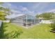 Enclosed pool area featuring a pool, patio furniture, and lush green grass at 1101 Mclean St, Dunedin, FL 34698