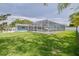 Backyard showcasing a screened-in pool with lush green grass and a spacious outdoor area at 1101 Mclean St, Dunedin, FL 34698