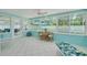 Bright sunroom with tiled floors and many windows overlooking the pool and backyard at 1101 Mclean St, Dunedin, FL 34698
