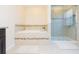 Serene bathroom featuring a soaking tub with tile surround, separate glass shower, and tile flooring at 11109 Carrick Stone St, Wimauma, FL 33598