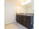 Stylish bathroom with granite double vanity, modern lighting, and white trim, offering a clean and updated design at 11109 Carrick Stone St, Wimauma, FL 33598