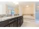 Elegant bathroom featuring a double vanity with granite countertops, soaking tub, and separate shower at 11109 Carrick Stone St, Wimauma, FL 33598
