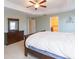 Bedroom with tray ceiling, neutral paint, dark wood dresser, carpet, and access to the Primary bathroom at 11109 Carrick Stone St, Wimauma, FL 33598