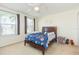 Cozy bedroom with two windows, plush carpet, and a bed adorned with a galaxy-themed comforter at 11109 Carrick Stone St, Wimauma, FL 33598