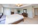 Spacious bedroom with neutral carpet, tray ceiling, dark wood furniture, and ample natural light at 11109 Carrick Stone St, Wimauma, FL 33598