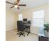Comfortable bedroom with a ceiling fan, natural light, and a workspace with a sleek black desk at 11109 Carrick Stone St, Wimauma, FL 33598