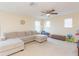 Spacious bonus room features a large sectional sofa, carpet, and natural light at 11109 Carrick Stone St, Wimauma, FL 33598