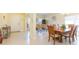 Open-concept living space featuring tile flooring, dining area with wood table, and front entryway at 11109 Carrick Stone St, Wimauma, FL 33598