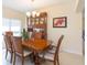 Formal dining room featuring wood table, chandelier, china cabinet, and large window at 11109 Carrick Stone St, Wimauma, FL 33598