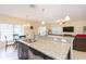 Open kitchen featuring a kitchen island with seating, granite countertops, and modern stainless steel appliances at 11109 Carrick Stone St, Wimauma, FL 33598