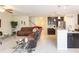 Open-concept living room flowing to kitchen with leather sofa and glass coffee table at 11109 Carrick Stone St, Wimauma, FL 33598