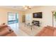Bright living room with sliding glass doors, tile flooring, and a ceiling fan at 11109 Carrick Stone St, Wimauma, FL 33598