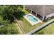 Aerial view of a backyard featuring a kidney-shaped pool, patio, spa and fenced yard at 11845 Newberry Grove Loop, Riverview, FL 33579