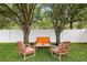 Cozy backyard seating area shaded by mature trees, perfect for outdoor relaxation at 11845 Newberry Grove Loop, Riverview, FL 33579