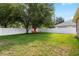 A spacious backyard features mature trees and a white fence, creating a serene outdoor space at 11845 Newberry Grove Loop, Riverview, FL 33579