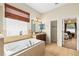 Bright bathroom features a soaking tub, and vanity with granite countertops at 11845 Newberry Grove Loop, Riverview, FL 33579