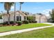 Inviting home featuring a well-manicured lawn, three-car garage, and mature palm trees at 11845 Newberry Grove Loop, Riverview, FL 33579