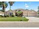 Charming single-story home with a three-car garage, well-manicured lawn, and mature palm trees at 11845 Newberry Grove Loop, Riverview, FL 33579