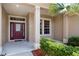 Inviting front entrance with decorative door, sidelight window, and manicured landscaping at 11845 Newberry Grove Loop, Riverview, FL 33579
