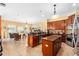 Open kitchen with granite counters, a central island, stainless appliances, and connection to living space at 11845 Newberry Grove Loop, Riverview, FL 33579